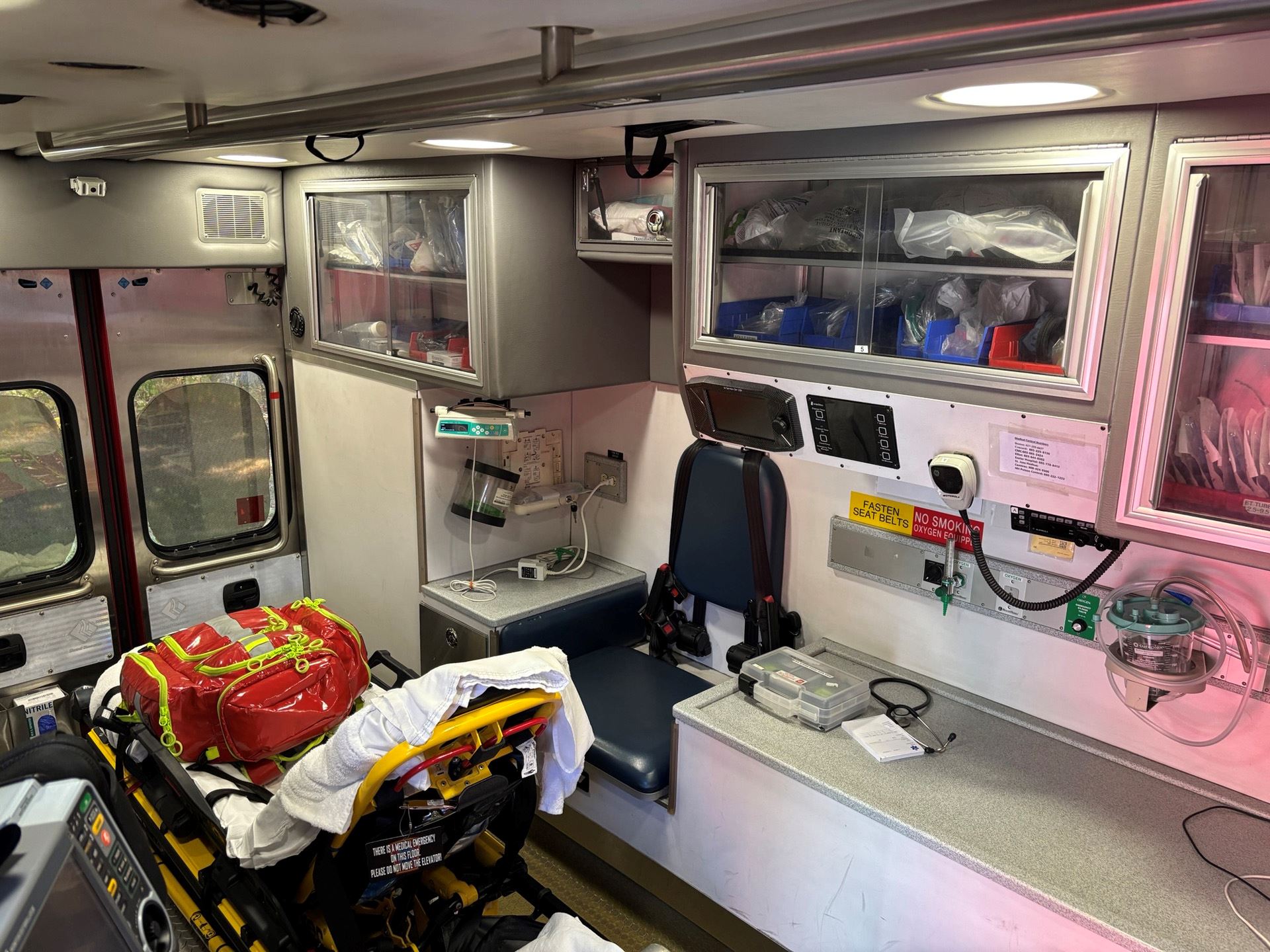 An interior view of the ambulance's patient compartment, showing a stretcher and medical equipmen